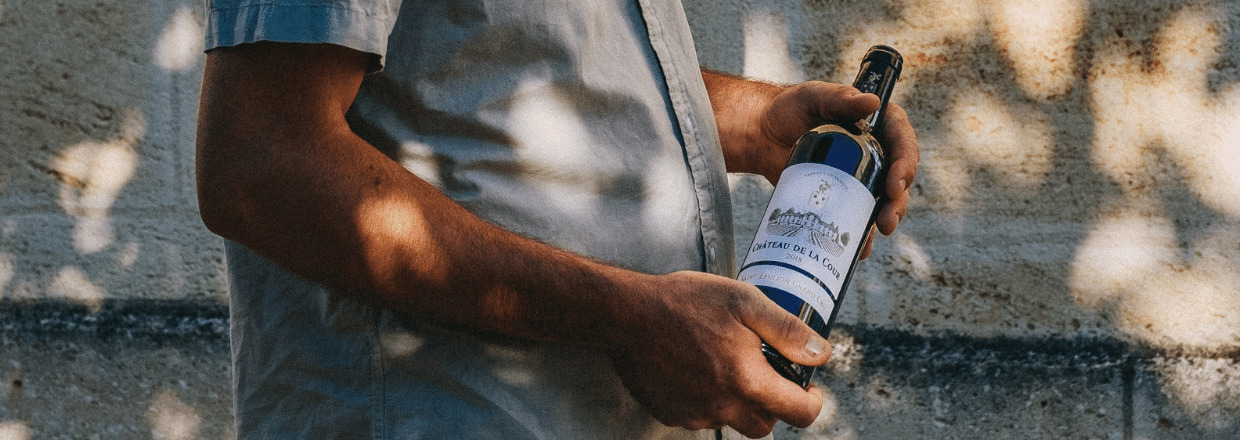 Producteur tenant une bouteille de Saint-Émilion Grand Cru